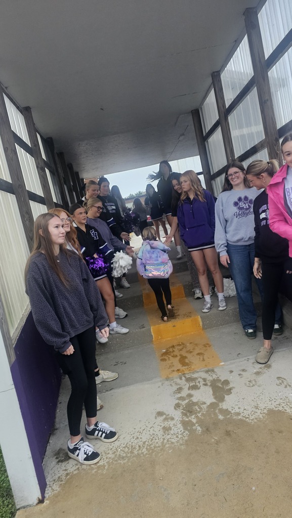 an elementary student walks past High school athletes