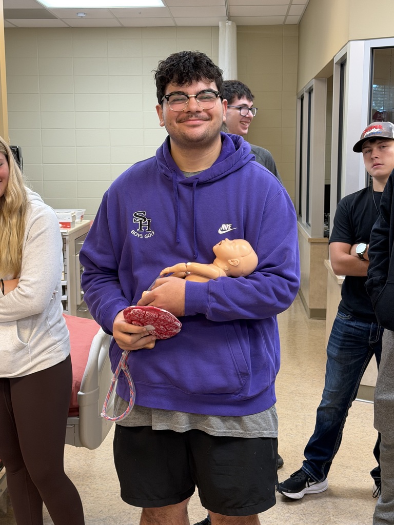 Student holding mannequin baby