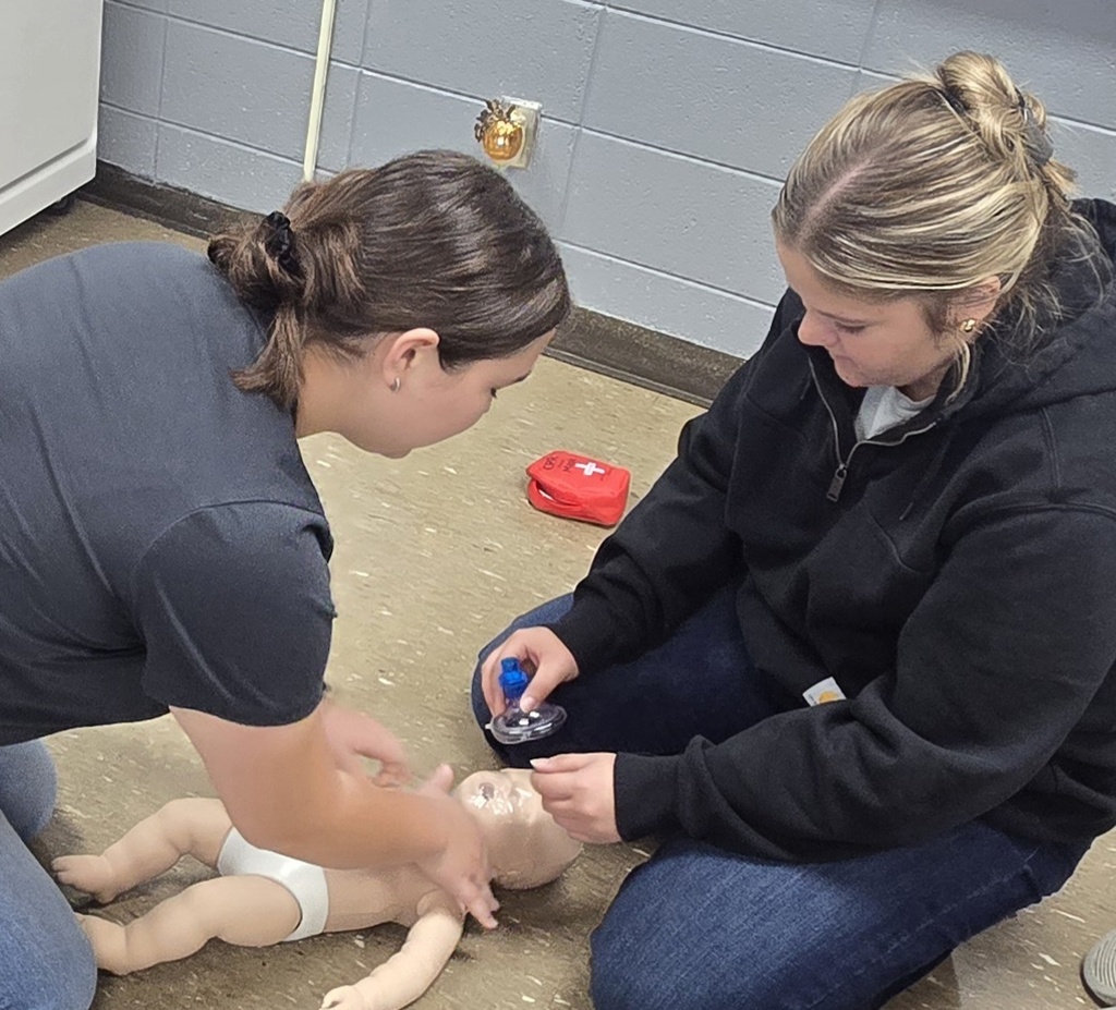 2 Students giving breath to infants.