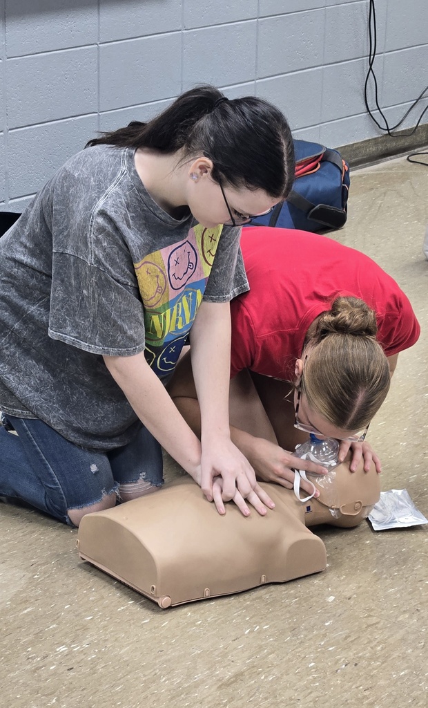 Student giving breath to infant.