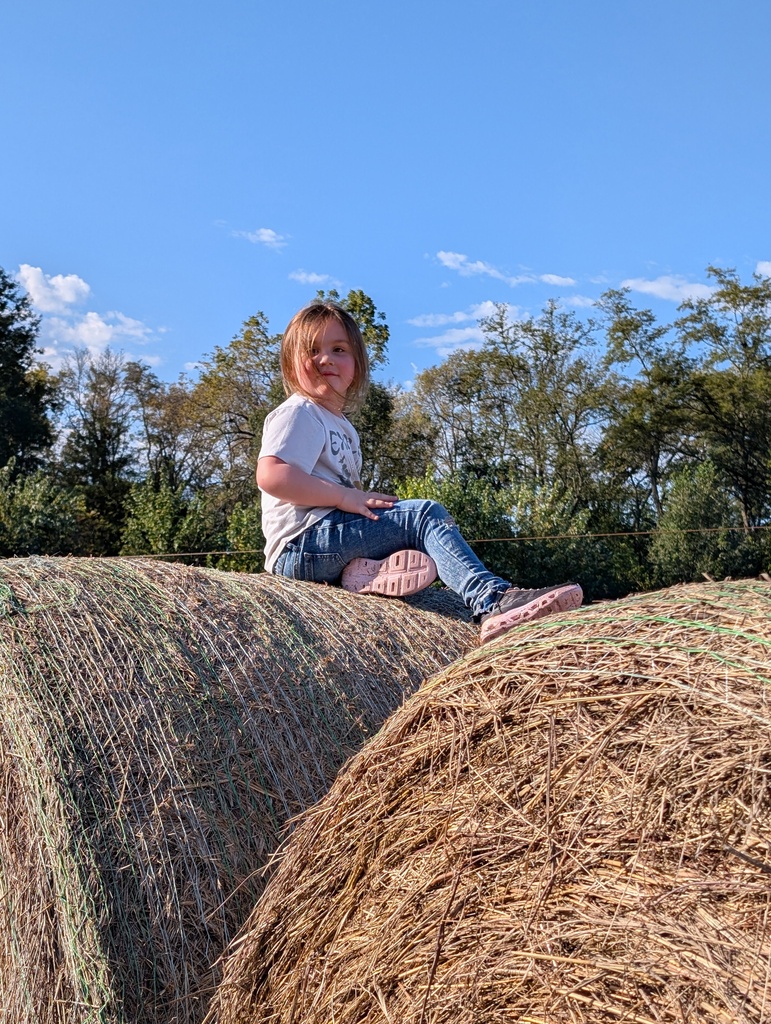 girl on hay bail