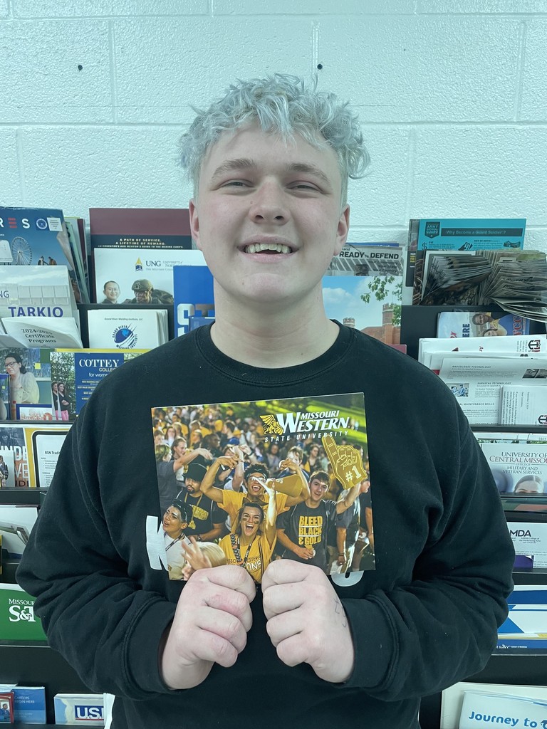 student holding college pennant