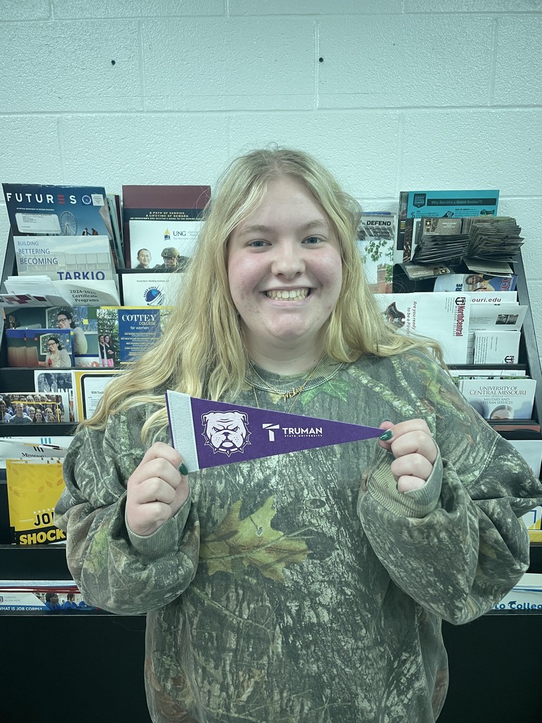 student holding college pennant