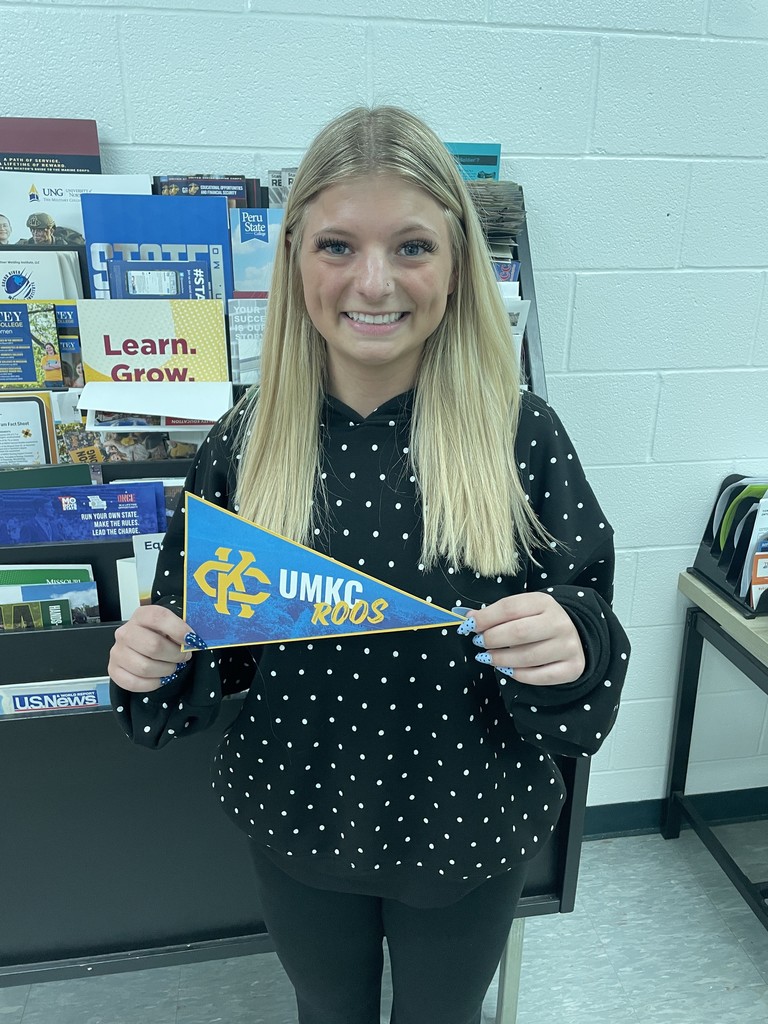 student holding college pennant