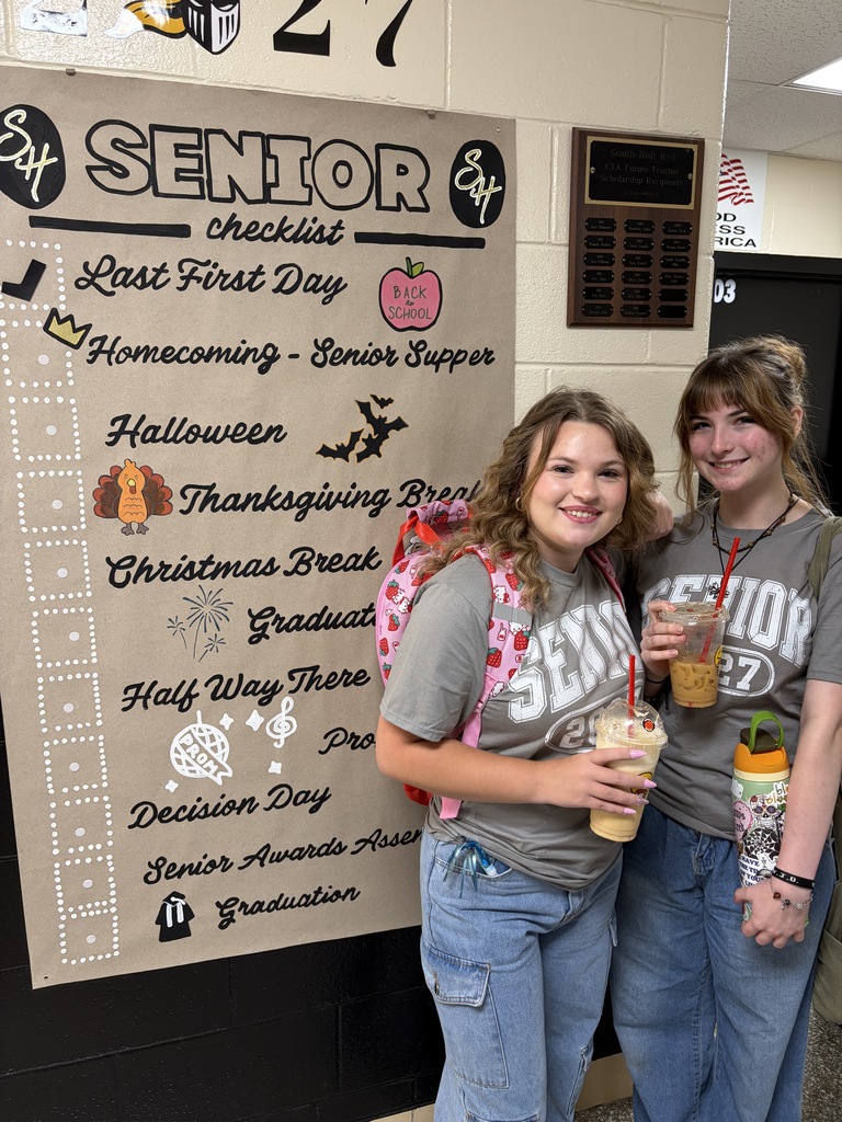 students posing next to banner