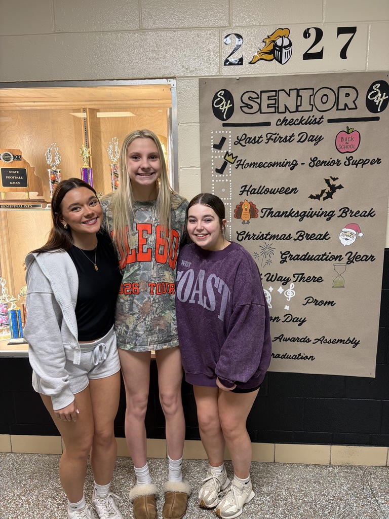 students posing in front of sign