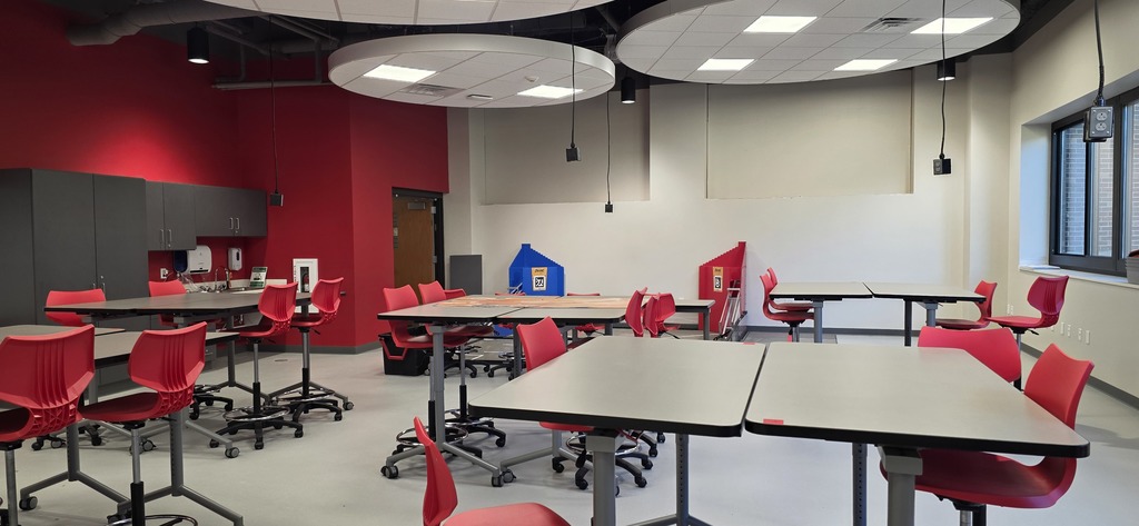 The STEAM Lab empty with High top tables and red chairs