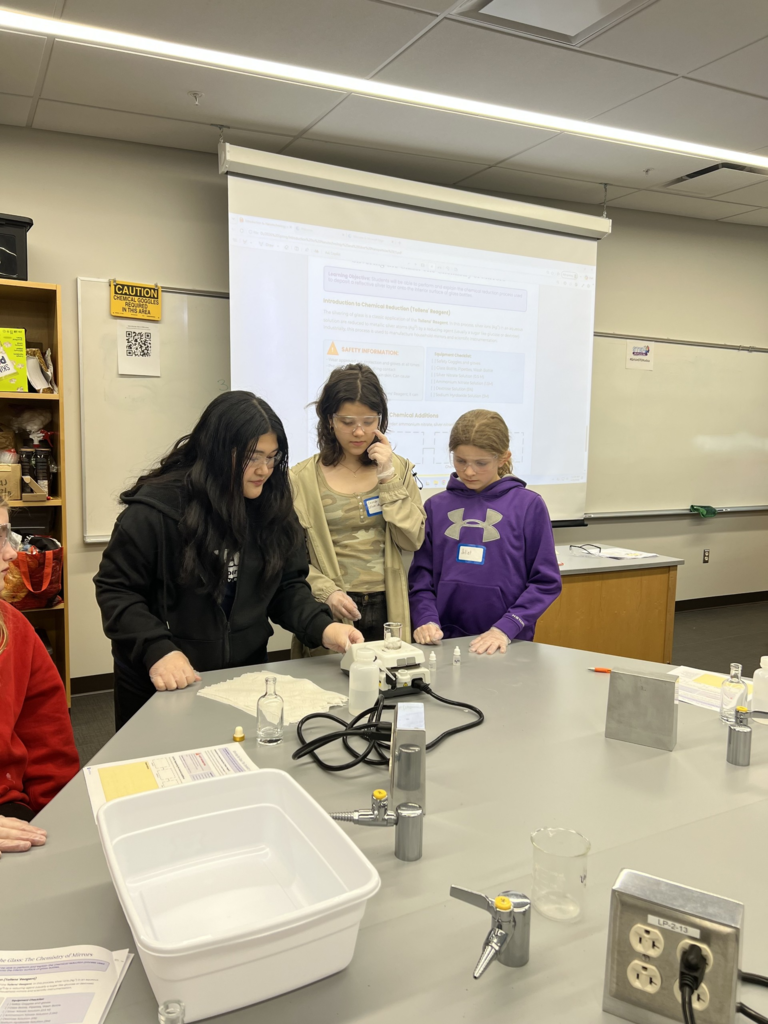 three girls looking at a science experiment