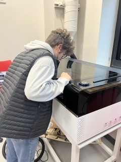 student using laser cutter