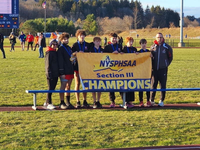 Boys standing with Coaches Michele Liendecker and Jack Bernard with the Section III Championship banner. 