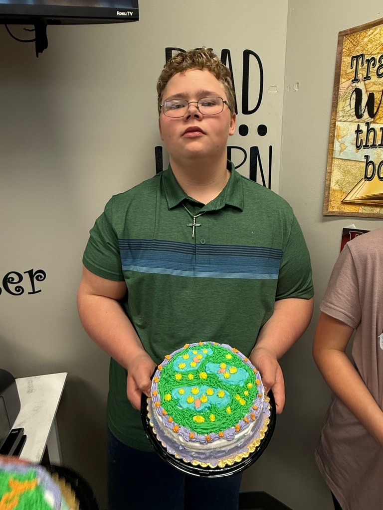 student holding decorated cake