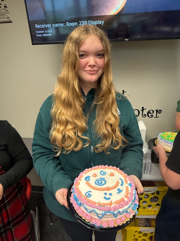 student holding decorated cake