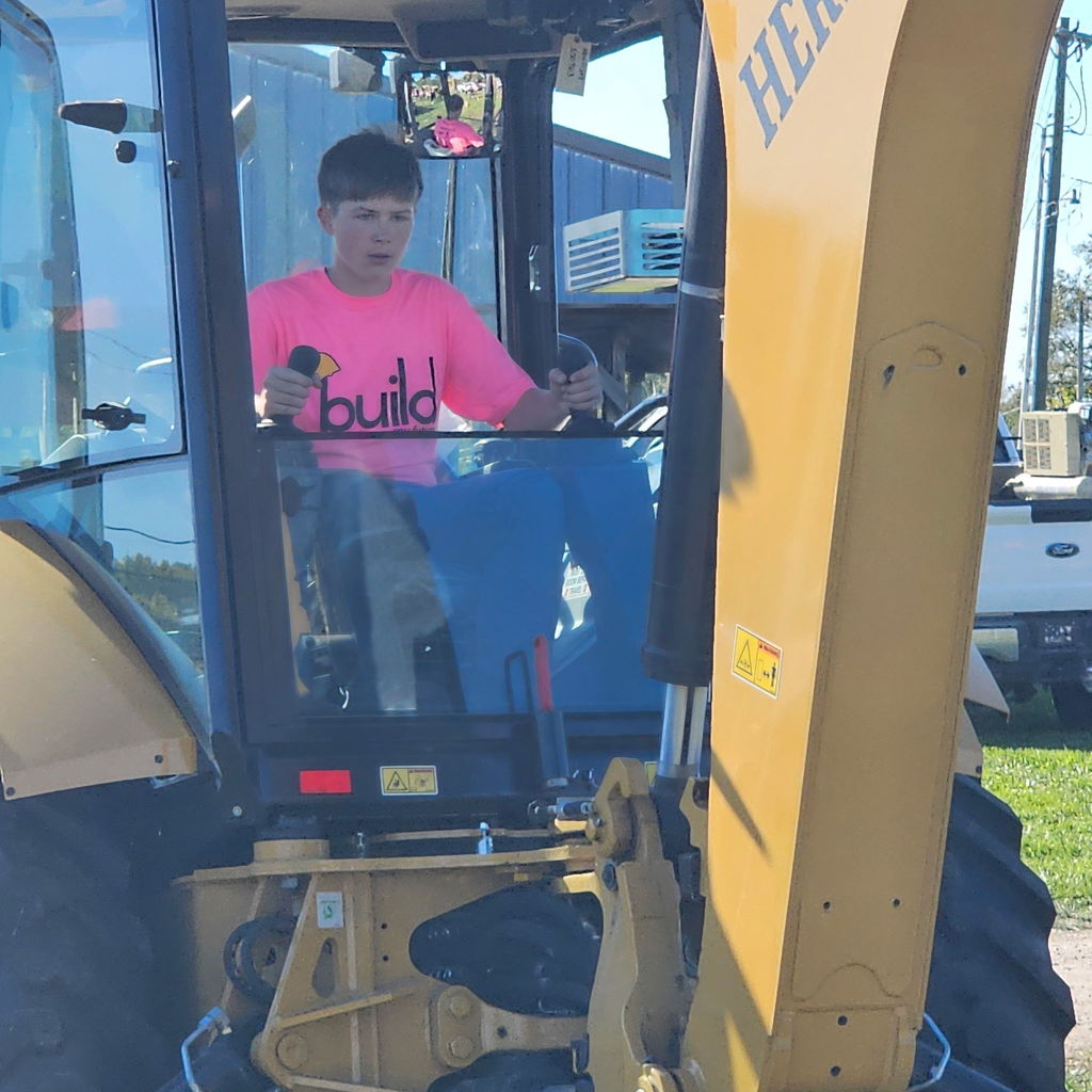 student operating a mini excavator