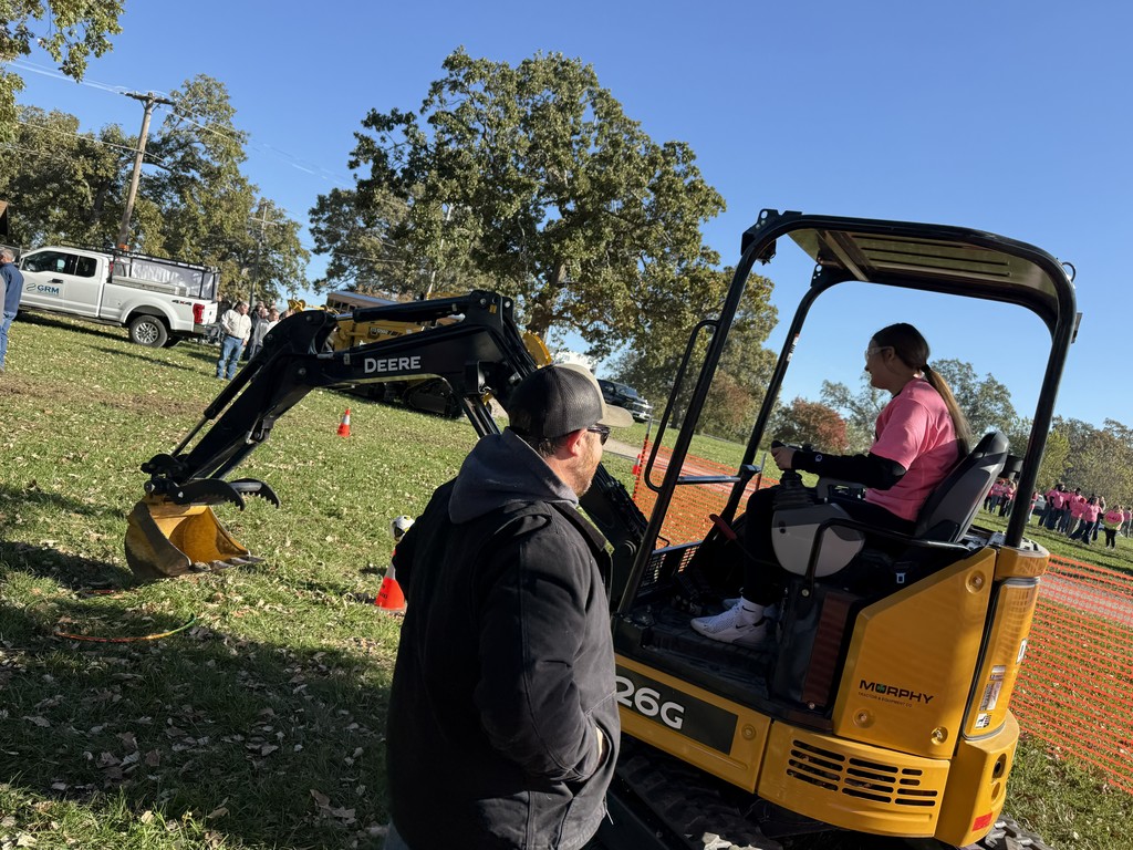 student operating a mini excavator