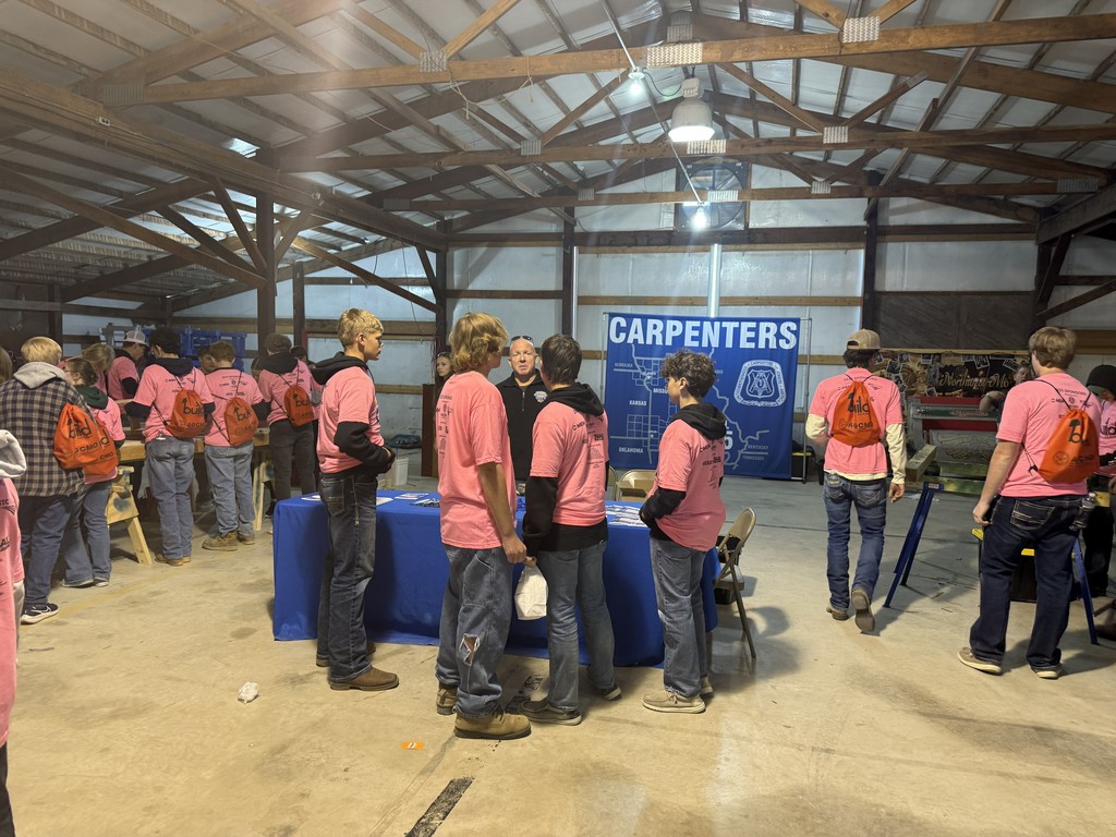 students standing at table listening to presenter