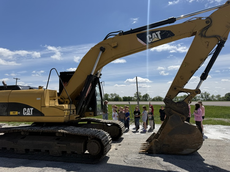 students behind excavator