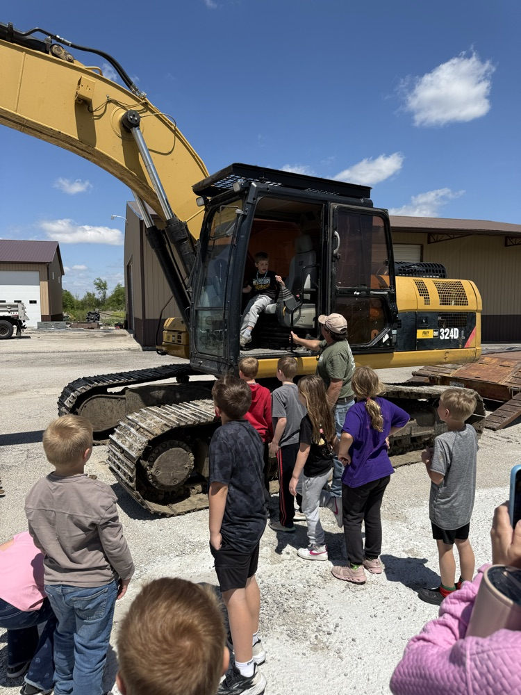 students around and in excavator