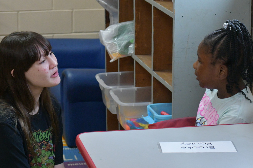 8th grader talking to a kindergarten students