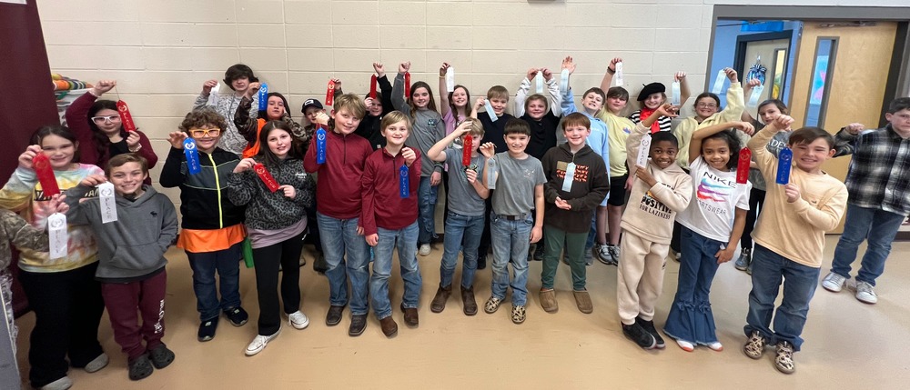 Group of students holding reading fair ribbons