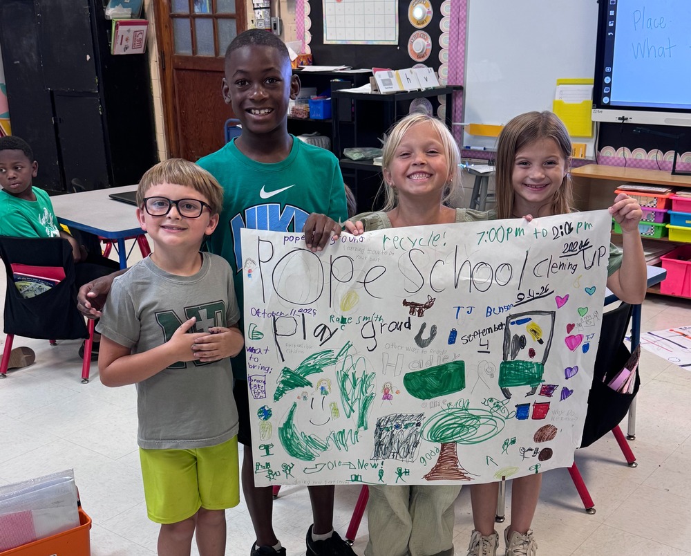 4 elementary students standing with a poster about clean up