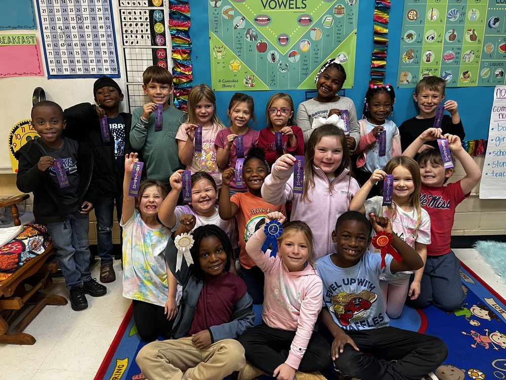 elementary students holding ribbons