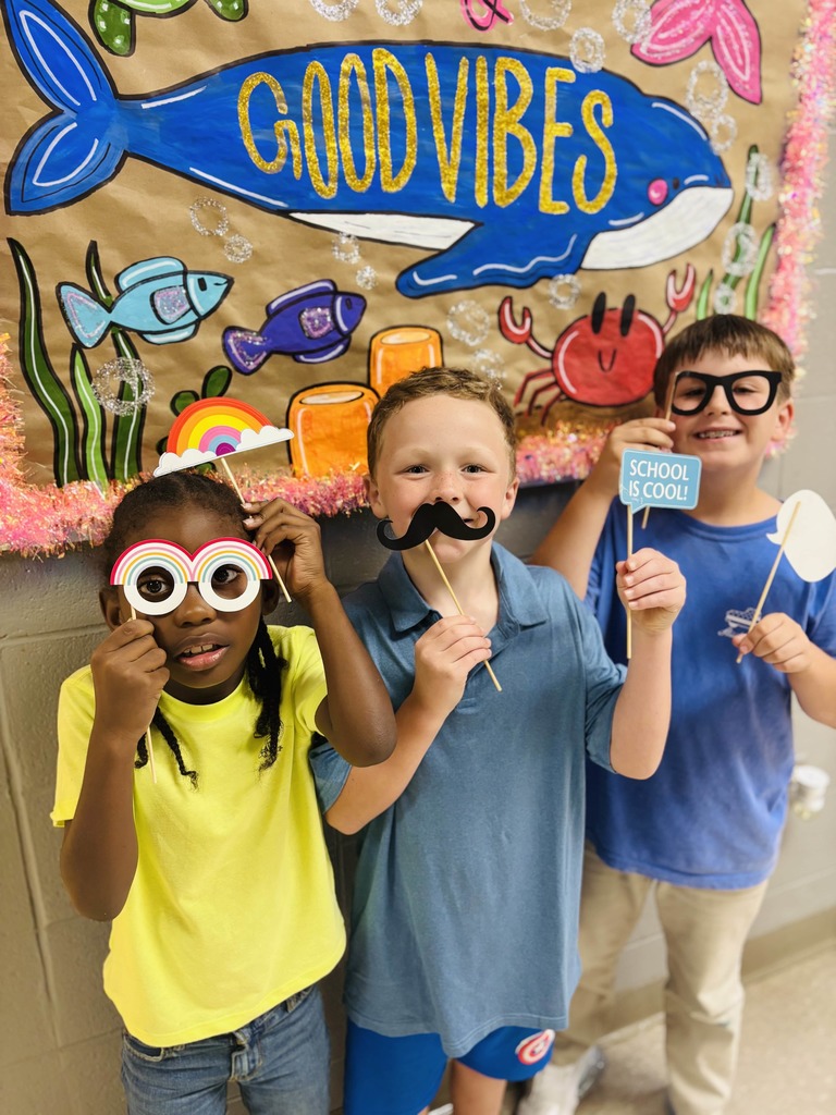elementary students posing with silly face masks