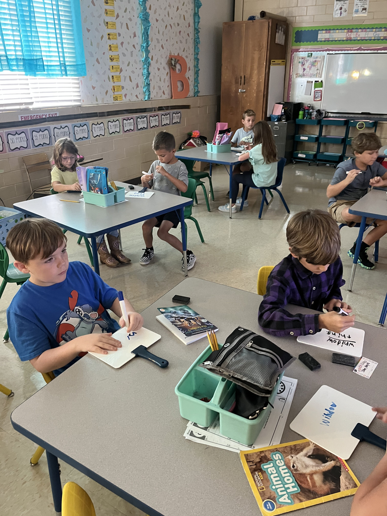elementary students working at tables