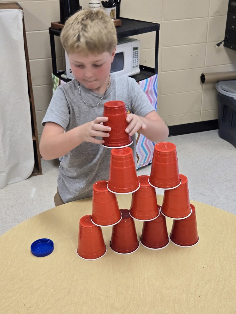 Elementary students stacking cups to complete a challenge