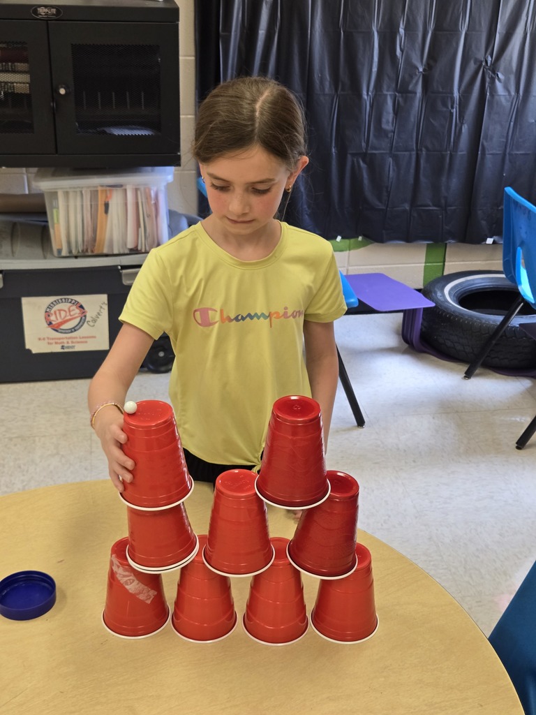 Elementary students stacking cups to complete a challenge