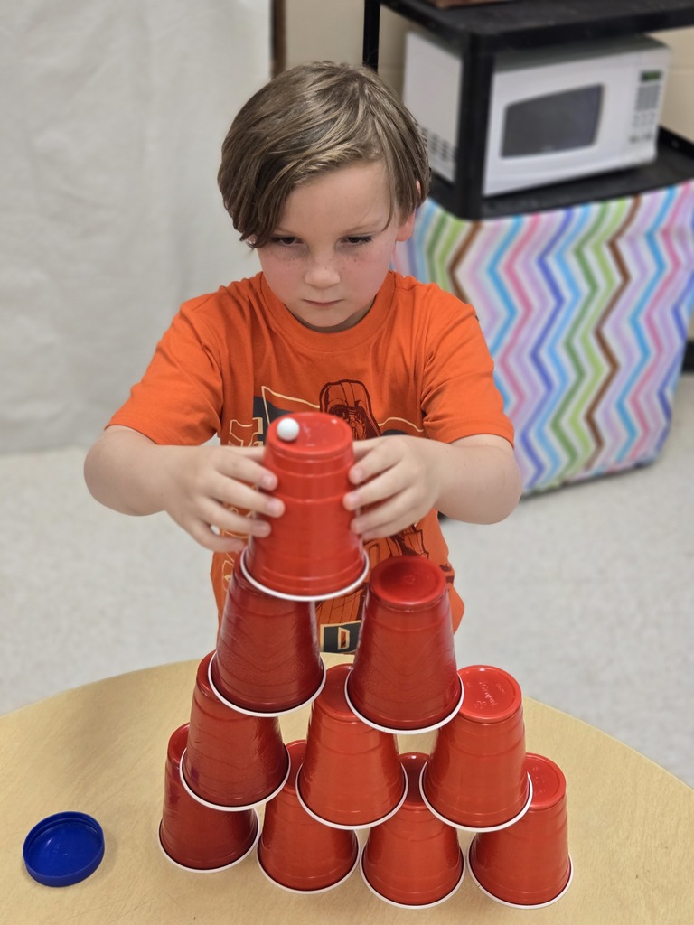 Elementary students stacking cups to complete a challenge