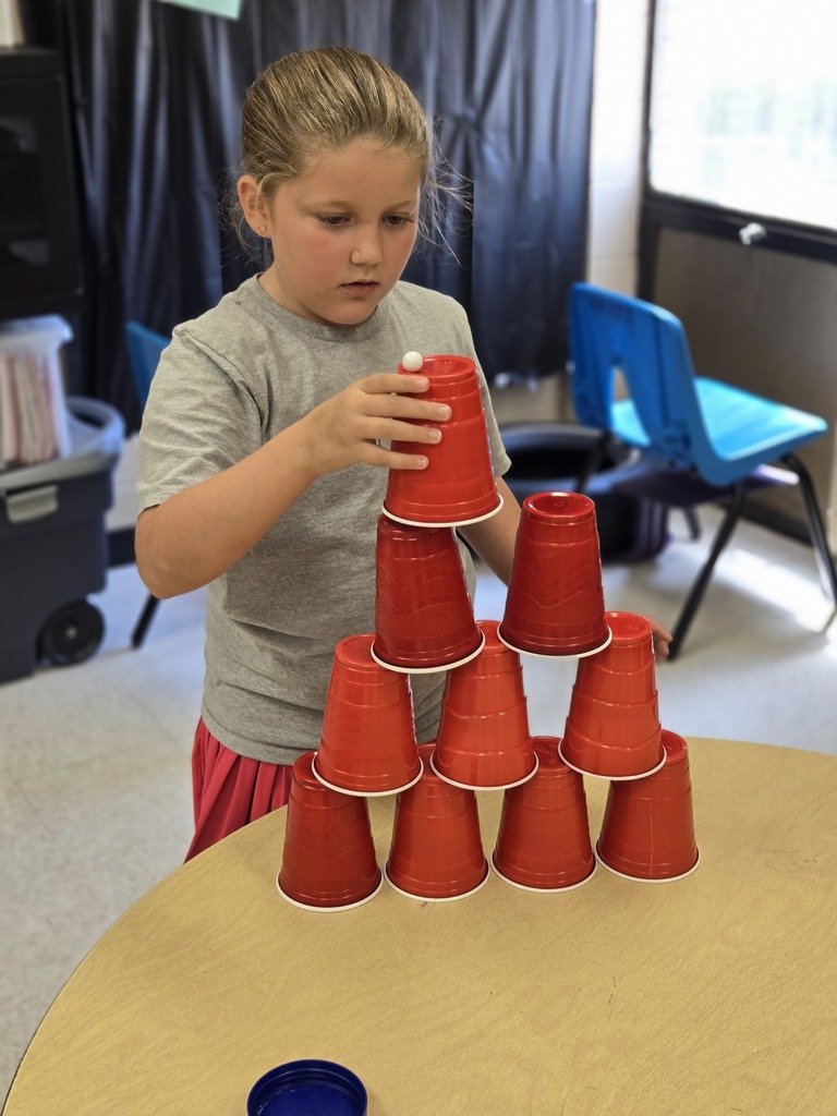Elementary students stacking cups to complete a challenge