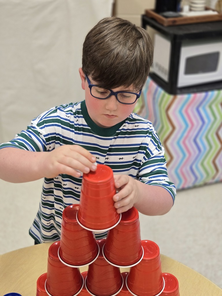 Elementary students stacking cups to complete a challenge