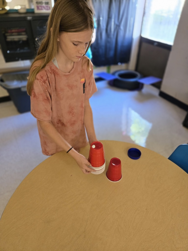 Elementary students stacking cups to complete a challenge