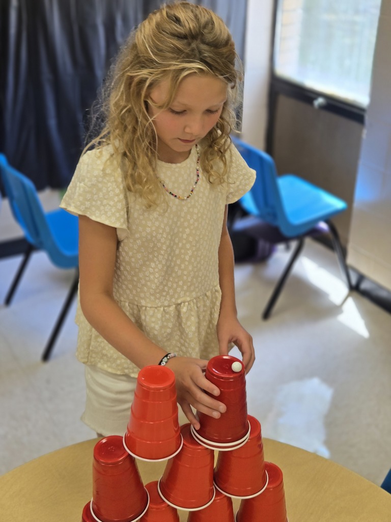 Elementary students stacking cups to complete a challenge
