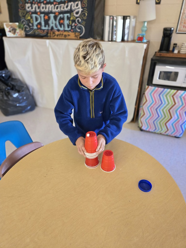 Elementary students stacking cups to complete a challenge