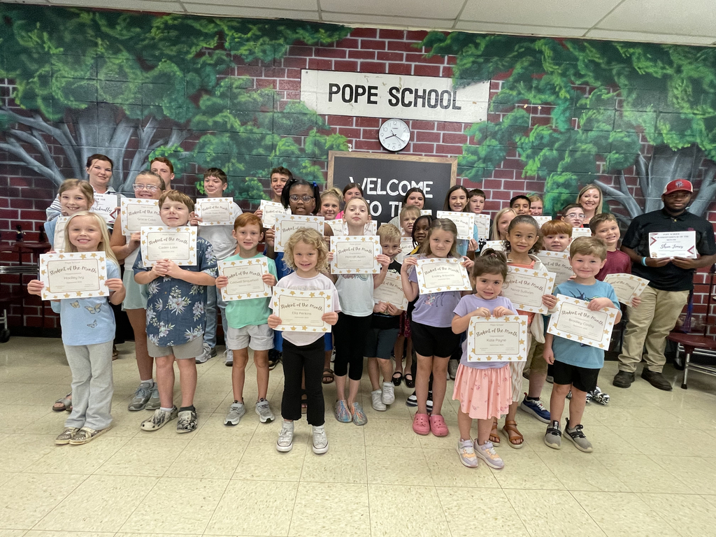 Elementary students holding award certificates