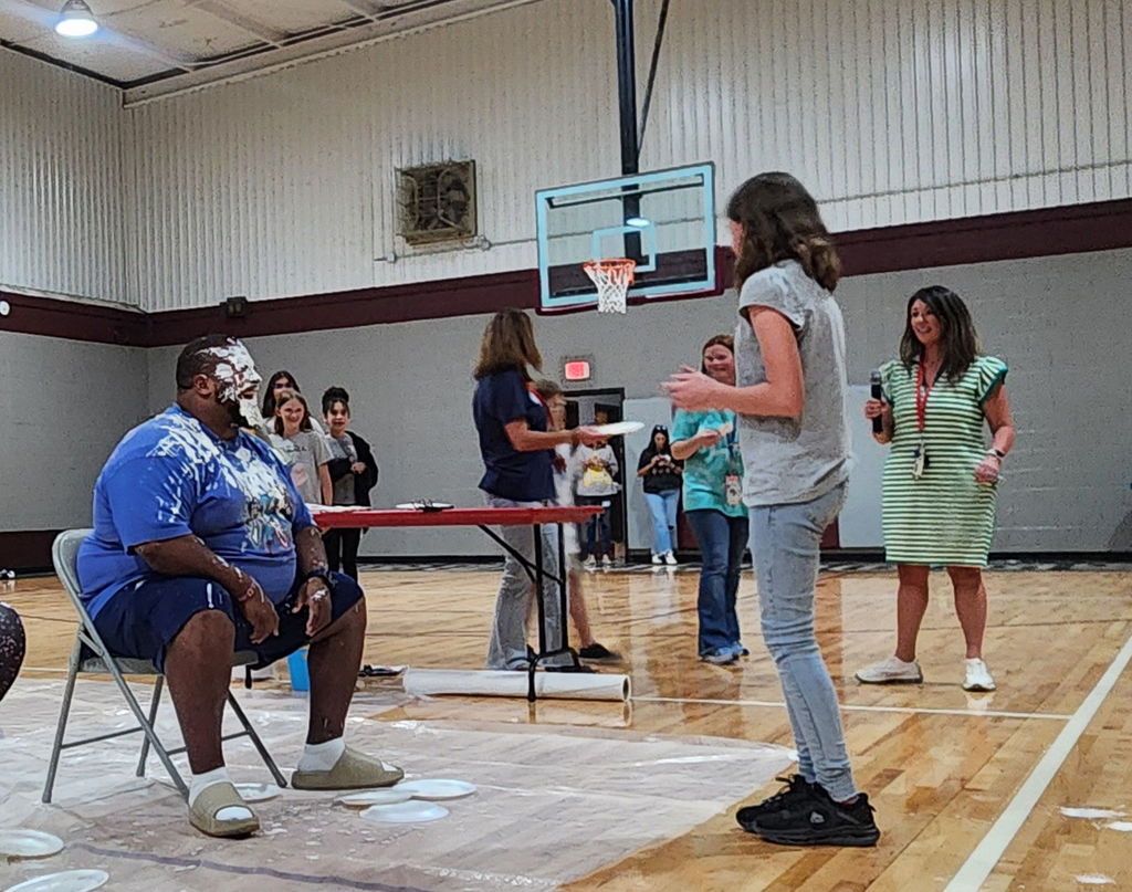 students in gymnasium stands at a pep rally
