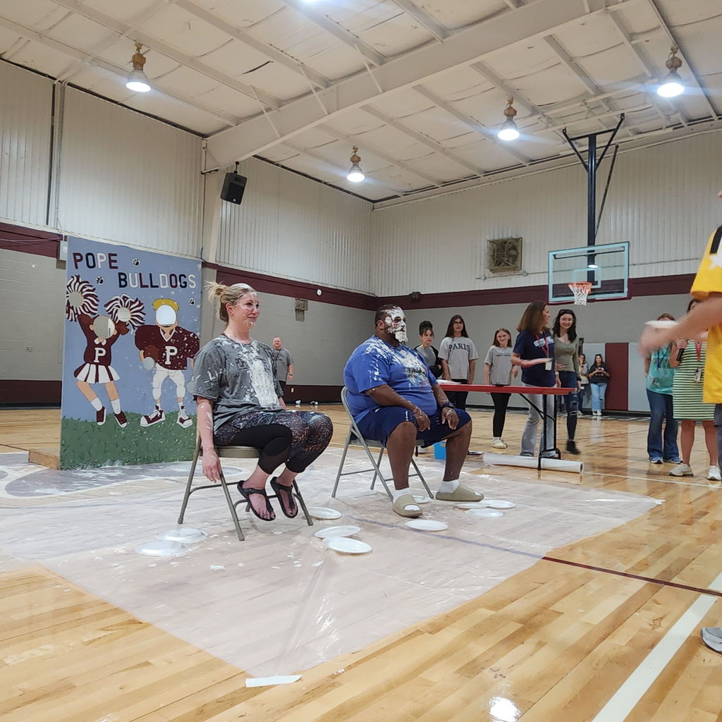 students in gymnasium stands at a pep rally