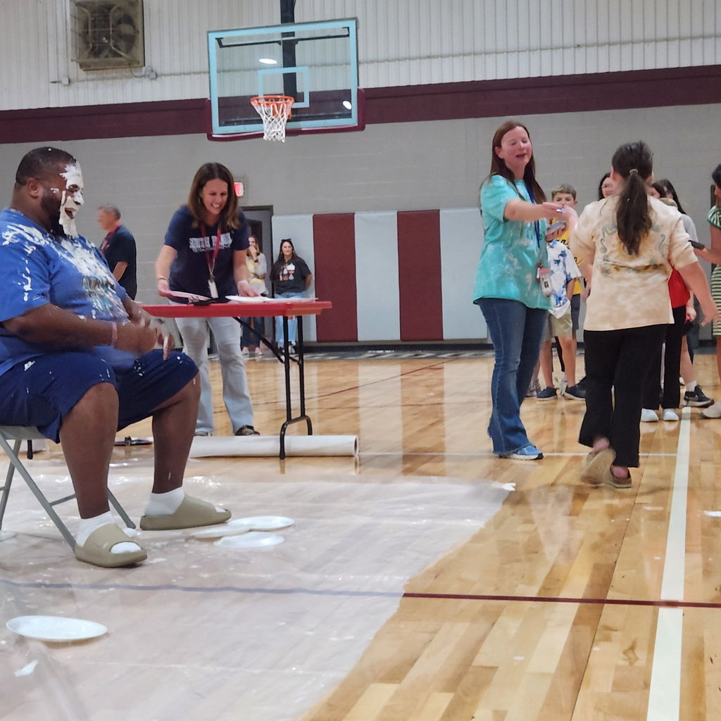 students in gymnasium stands at a pep rally