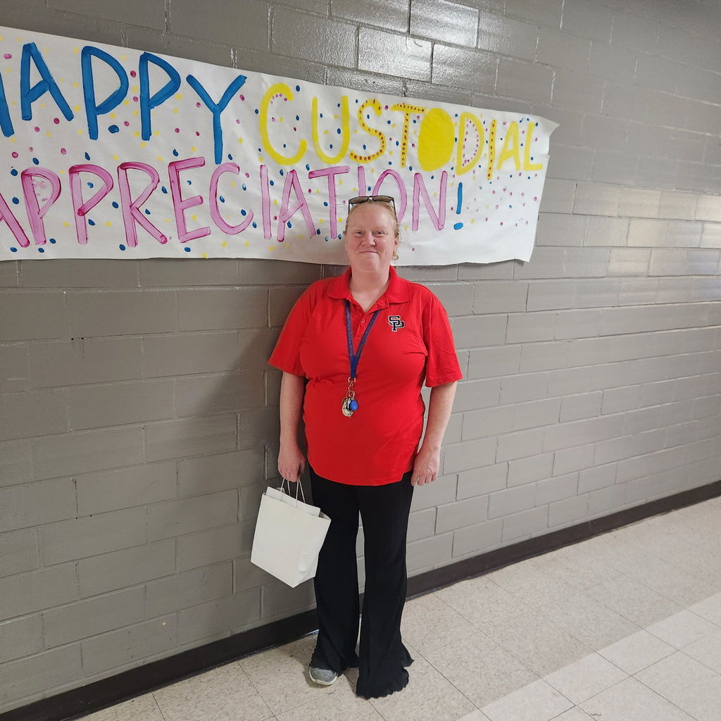 custodians standing in front of a sign