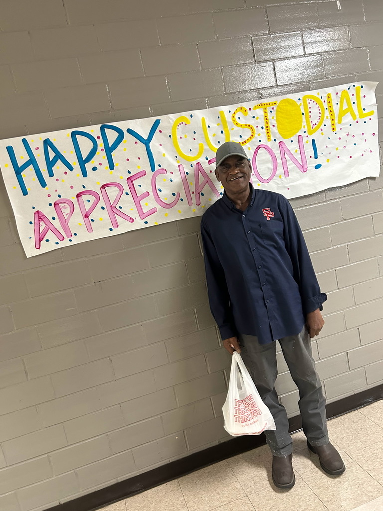 custodians standing in front of a sign