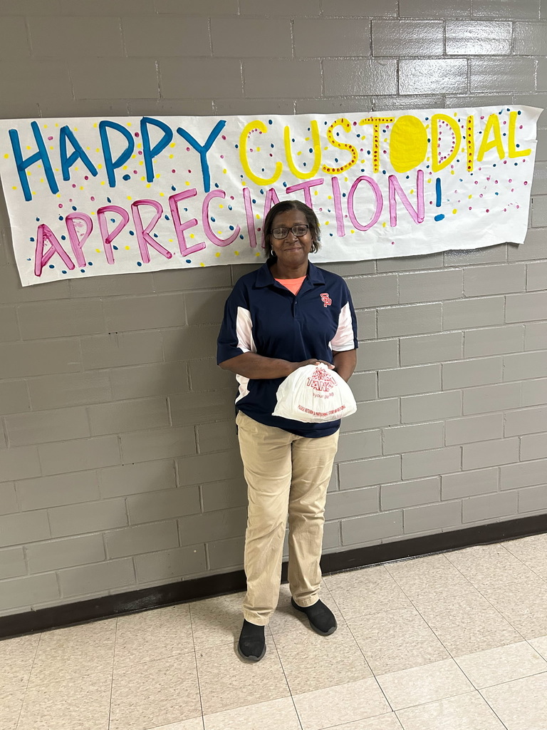 custodians standing in front of a sign