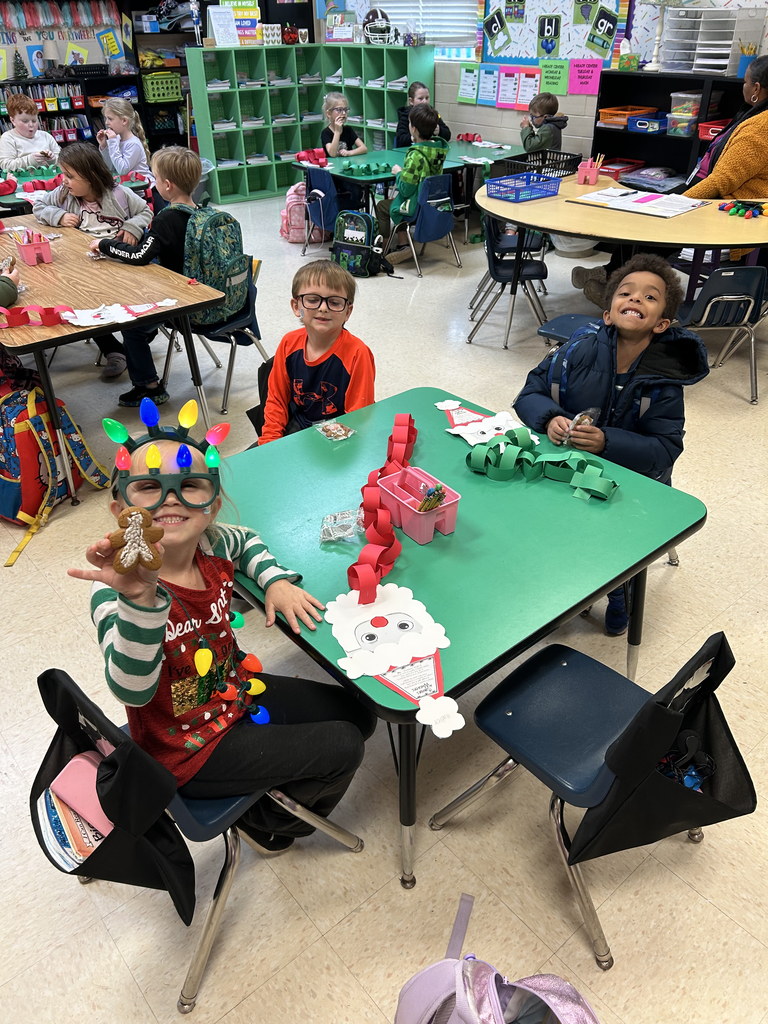 first grade students holding gingerbread men cookies