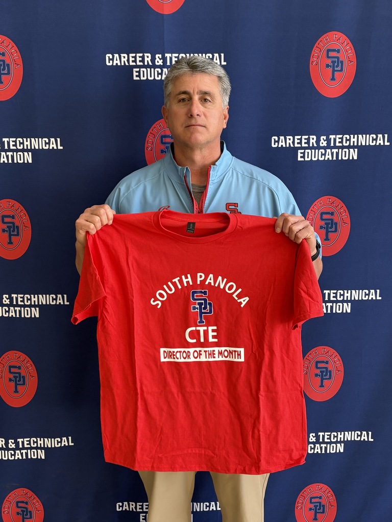 Coach Higdon displays a CTE shirt.