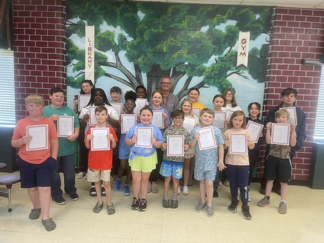 group of elementery students standing with certificates