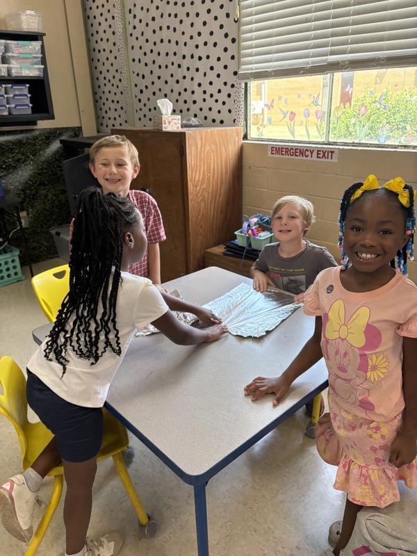 2nd  grade students working on aluminum foil boats