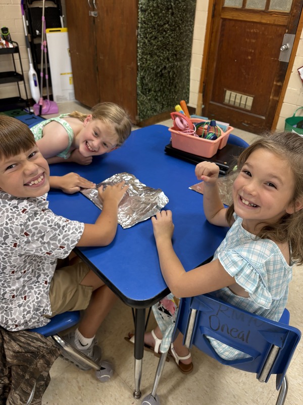 2nd  grade students working on aluminum foil boats