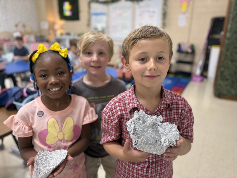 2nd  grade students working on aluminum foil boats