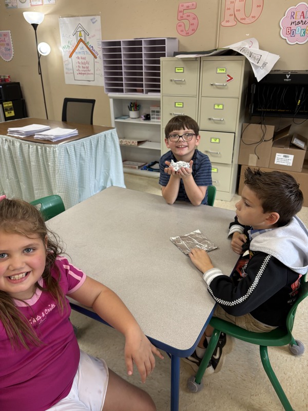 2nd  grade students working on aluminum foil boats
