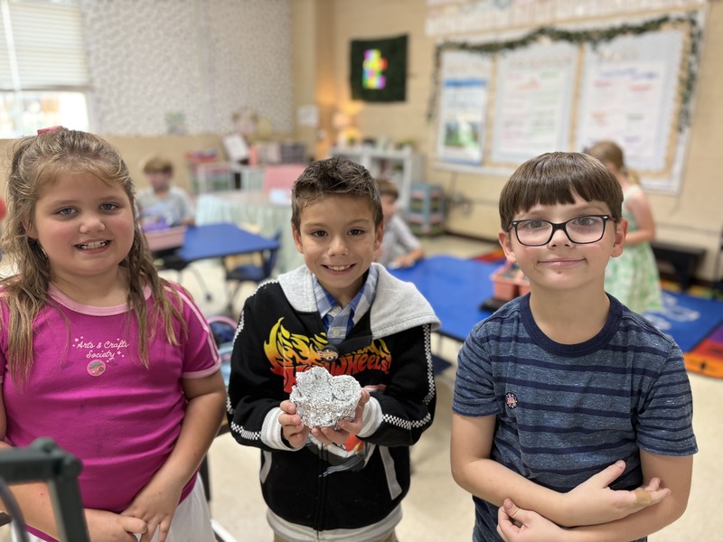 2nd  grade students working on aluminum foil boats